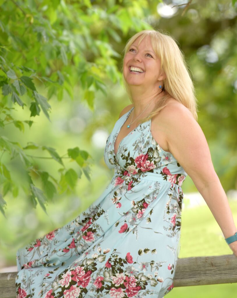 A woman in floral dress smiling for the camera.