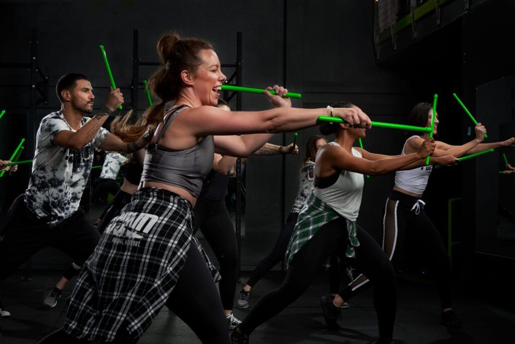 A group of people holding green sticks in their hands.